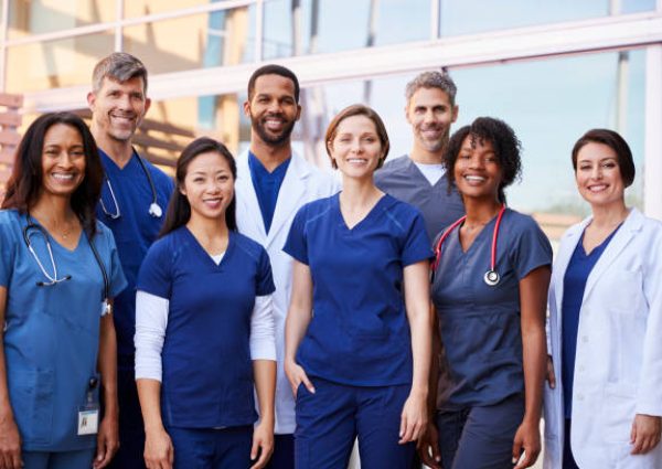 Smiling medical team standing together outside a hospital